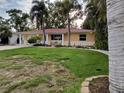 Charming single-story home with a red roof, lush lawn, landscaping and an attached one car garage at 4210 Carson Ne St, St Petersburg, FL 33703