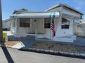 Exterior view of a quaint mobile home featuring awnings, stairs and an American flag at 4851 W Gandy Blvd # B1L14, Tampa, FL 33611