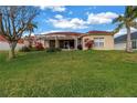 Spacious backyard with lush green lawn, mature trees, and screened in patio; perfect for outdoor living at 540 Somerhill Ne Dr, St Petersburg, FL 33716