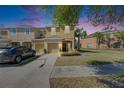 Sunset view of a cozy townhome featuring a private garage, lush landscaping and a colorful sky at 6907 Holly Heath Dr, Riverview, FL 33578