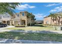 Charming two-story townhouse with an attached garage, palm trees and a well-manicured lawn at 6907 Holly Heath Dr, Riverview, FL 33578