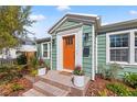 Close up of the front door and porch. Orange front door with brick steps and potted plants at 777 29Th N Ave, St Petersburg, FL 33704