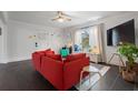 Cozy living room with a bright red sofa, flat screen tv, and ample natural light at 803 S Evergreen Ave, Clearwater, FL 33756