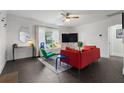 Inviting living room featuring a comfortable red sofa, large window, and stylish decor at 803 S Evergreen Ave, Clearwater, FL 33756