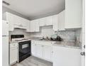 Bright kitchen features white cabinets, updated countertops, and a sleek black stove at 803 W Warren St, Plant City, FL 33563