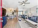 Open-concept living area with wood floors, ceiling fan, and a mirrored wall for added spaciousness at 8220 112Th N St # 206, Seminole, FL 33772