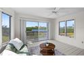Inviting sunroom with large windows offering a view of the lake and natural surroundings at 1020 Lake Avoca Dr, Tarpon Springs, FL 34689