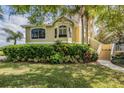 Charming tan home with well-maintained landscaping and a sidewalk to the front steps at 104 Westbrook Ct, Safety Harbor, FL 34695