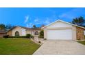 Charming single-Gathering home with lush green lawn, stone accents, and a convenient two-car attached garage at 10440 Laval St, Spring Hill, FL 34608