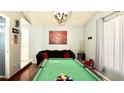 Open game room with billiard table, stylish lighting, and a cozy seating area for entertainment at 10440 Laval St, Spring Hill, FL 34608