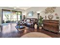 Well-lit living room featuring hardwood floors, leather sofa, tasteful décor, and sliding glass doors at 11190 Windsor Place Cir, Tampa, FL 33626