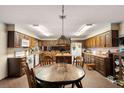 Wide kitchen offers wood cabinets, island, brick floors, eat in space, and appliances at 11327 Carter Grove Ln, Thonotosassa, FL 33592