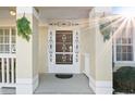 Close-up of the front door with decorative ironwork, surrounded by porch columns at 2325 W Del Webb Blvd, Sun City Center, FL 33573
