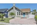 Charming bungalow-style home with a brick driveway, well-manicured lawn, and inviting light blue front door at 2835 3Rd N Ave, St Petersburg, FL 33713