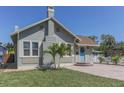 Charming single-story home featuring a brick chimney, blue door, tidy landscaping, and brick paver driveway at 2835 3Rd N Ave, St Petersburg, FL 33713