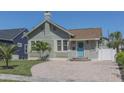 Charming single-story home featuring a brick chimney, blue door, tidy landscaping, and brick paver driveway at 2835 3Rd N Ave, St Petersburg, FL 33713