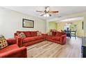 Bright living room featuring hardwood floors and comfortable red couches at 3002 Mojave Oak Dr, Valrico, FL 33594
