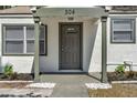 Charming home featuring a covered front door and decorative stone landscaping at 304 E Hanlon St, Tampa, FL 33604