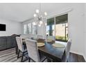 Dining area has an eye-catching light fixture, large windows and sliding glass doors to the backyard at 34244 Radley Way, Wesley Chapel, FL 33545