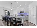 Modern kitchen features gray cabinets, granite counters, stainless appliances, and an island with bar seating at 34244 Radley Way, Wesley Chapel, FL 33545