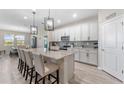 Spacious kitchen with a central island, stainless appliances, white cabinets, and pendant lighting at 34311 Evergreen Hill Ct, Wesley Chapel, FL 33545