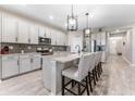 Modern kitchen with a large island, granite countertops, stainless steel appliances, and stylish pendant lighting at 34311 Evergreen Hill Ct, Wesley Chapel, FL 33545