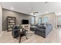 Inviting living room featuring comfortable seating, a ceiling fan, and ample natural light from large windows at 34311 Evergreen Hill Ct, Wesley Chapel, FL 33545