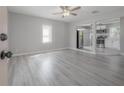 Bright, open-concept living room featuring gray wood floors, modern ceiling fan, and view of the kitchen at 3714 38Th N Ave, St Petersburg, FL 33713