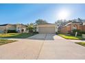 Charming single Gathering home featuring a two-car garage and manicured front lawn at 5039 Gato Del Sol Cir, Wesley Chapel, FL 33544