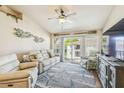 Cozy living room with white seating, a balcony, a ceiling fan and TV at 5088 Royal Palms Way # 304, New Port Richey, FL 34652