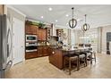 Spacious kitchen boasts dark wood cabinetry, a large island with seating, and modern stainless steel appliances at 5305 Sagecrest Dr, Lithia, FL 33547
