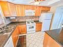 Efficient kitchen featuring wood cabinets, modern appliances, and neutral countertops at 6020 Shore S Blvd # 1009, Gulfport, FL 33707