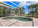 Inviting screened-in pool area with a spa, tiled patio, and comfortable lounge chairs for relaxation at 708 Islebay Dr, Apollo Beach, FL 33572