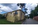 Exterior view of a yellow two-story condo with small balconies and a wood fence at 7502 Bolanos Ct, Tampa, FL 33615