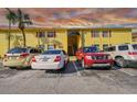 Condominium building with yellow facade, red shutters, parking spaces, and beautiful sunset clouds at 7512 Dolonita Dr # 7512, Tampa, FL 33615