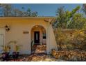 Inviting arched front entrance with decorative tile and stone accents, leading into the home at 8740 Forest Lake Dr, Port Richey, FL 34668