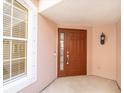 Inviting front entrance with sidelight, lantern and a secure brown door with ADT security system at 891 Lantern Way # 13-103, Clearwater, FL 33765