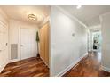 A long hallway with beautiful hardwood floors and decorative wainscoting leading to a room with a view at 100 Bluff View Dr # 614A, Belleair Bluffs, FL 33770
