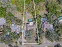 Aerial view of property with pool, tennis court, and surrounding lush greenery at 10100 Grove Dr, Port Richey, FL 34668