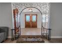 Grand foyer featuring decorative archway, tile flooring, and stylish double doors at 10100 Grove Dr, Port Richey, FL 34668