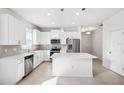 Modern kitchen featuring white cabinets, stainless steel appliances, and a center island with counter seating at 13001 Satin Lily Dr, Riverview, FL 33579