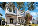 Inviting two-story home with white exterior, covered front porch, and lush landscaping for great curb appeal at 145 16Th Ne Ave, St Petersburg, FL 33704