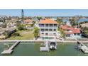 Aerial view of a waterfront home with a pool, balconies, a private dock, and lush tropical landscaping at 16327 Redington Dr, Redington Beach, FL 33708