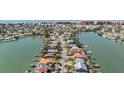An elevated view showcases waterfront homes with private boat docks along canal waterways and clear blue skies at 16327 Redington Dr, Redington Beach, FL 33708