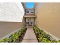 Inviting entrance with manicured landscaping leading to the front doors and natural lighting at 2028 Kings Palace Dr # 202, Riverview, FL 33578