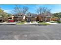 Charming row of townhouses with well-manicured lawns and ample parking on a tree lined street at 2028 Kings Palace Dr # 202, Riverview, FL 33578