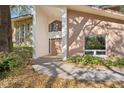 Stylish home front entrance with stone and light brown siding, double doors, and mature landscaping at 2112 Laurence Dr, Clearwater, FL 33764