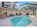Screened-in backyard swimming pool with ample patio space for dining and lounging at 2112 Laurence Dr, Clearwater, FL 33764