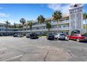 Multi-story condo complex with ample parking, featuring mature palm trees and nicely maintained landscaping at 2401 Ecuadorian Way # 57, Clearwater, FL 33763