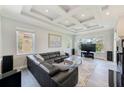Open-concept living room with coffered ceilings, large windows, and a modern fireplace at 250 Seagate Ct, Dunedin, FL 34698
